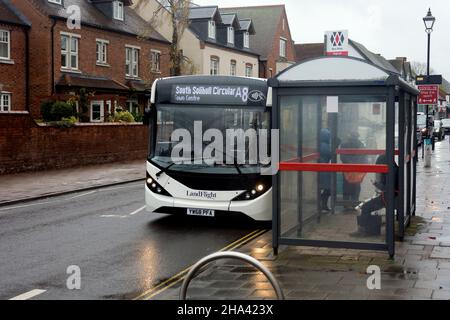 Ein lokaler Bus`s der High Street an einem nassen Wintertag, Knowle, West Midlands, England, Großbritannien Stockfoto